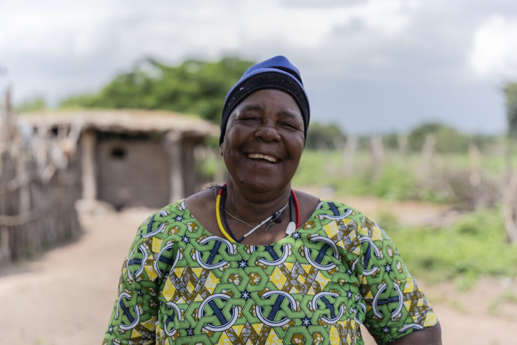 Cataract patient Holo smiles while standing outside her home.